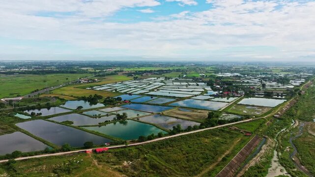 Fishponds in Dapdap Bamban Tarlac reflecting bright clouds and tropical blue sky