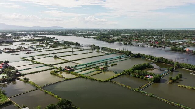 Backward drone view of fishpond village and river in Binmaley Pangasinan