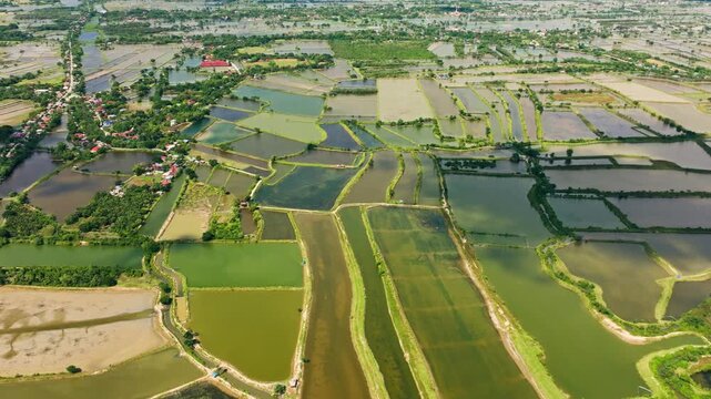 Tilted drone shot sliding left over fishpond landscape in Pangasinan area