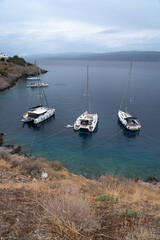 Hydra Island harbor on a cloudy day with yachts moored along the waterfront in the Saronic Gulf, Greece.