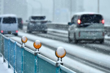 雪の日に橋を渡り越境する車とデリネーター　新荒川大橋