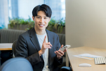 オフィスでスマホを使うビジネスマン