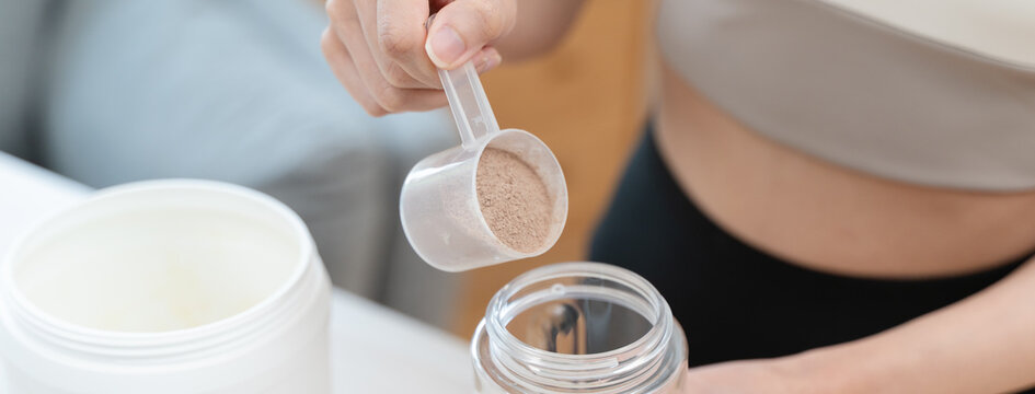 Diet meal replacement for weight loss, asian young woman in sportswear, hand in holding scoop making protein into bottle