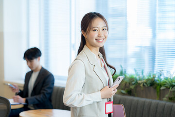 オフィスでスマホを持つビジネスウーマン