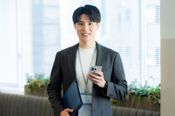 オフィスでスマホを使うビジネスマン