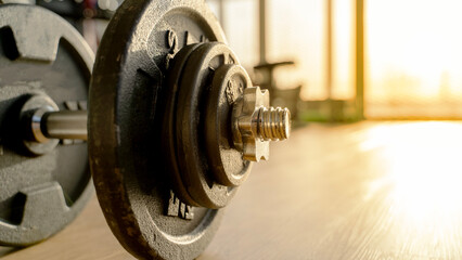 Barbell in the gym at sunset