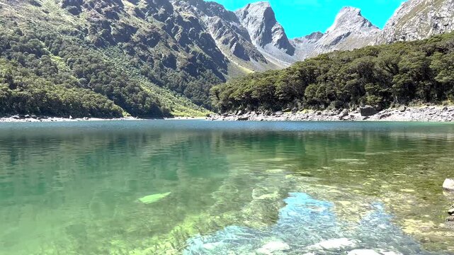 Routeburn Track, Great Walk, New Zealand. Pristine Lake MacKenzie and high mountains, sunny.