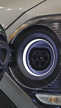 A male hand opens the charging port of an electrocar