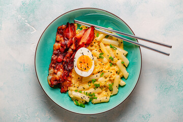 Korean street food - creamy rapokki served with bacon and egg.