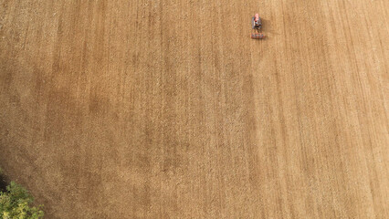Vintage crawler tractor cultivating agricultural land in rural Tuscany, Italy, an aerial top down view of farming preparing soil for sowing crops © Antonia