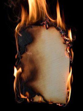 Burning piece of paper with flames on black background