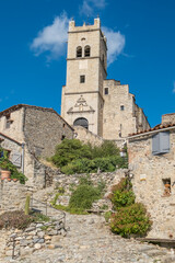 Saint Vincent church tower and stone houses in the village of Eus France