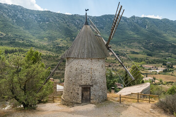 Historic stone windmill with wooden sails in the village of Cucugnan France