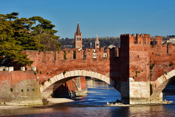View of Verona medieval Scaliger Bridge over Adige River with old bell towers