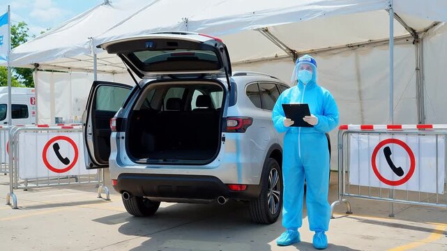 Person in protective suit at vehicle checkpoint
