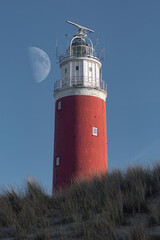 Red lighthouse on Texel island with moon in the sky, Netherlands