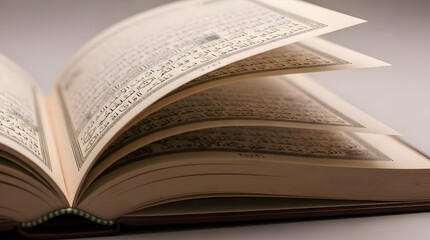 Obraz premium An Quran with pages turned down, displaying text, on a gray surface, viewed from the side