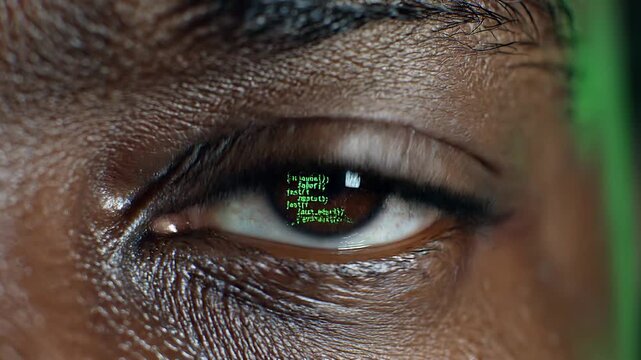 Close-up of a programmer's eye reflecting a screen full of scrolling green JavaScript code.