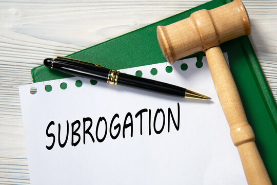 SUBROGATION - word in white paper against the background of a green folder and a judge's gavel
