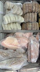 Packaged seafood assortment in refrigerated display case at supermarket  