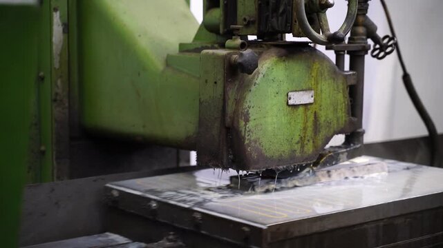 Close-up of a grinding machine smoothing a steel mold part in a factory. Concept of precision engineering, industrial manufacturing business, and production finance.