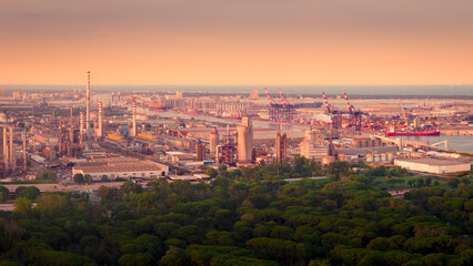 Naklejka premium Drone view of industrial and port area of Ravenna,production district is made up of a chemical and petrochemical pole, thermoelectric and metallurgical plants at sunset