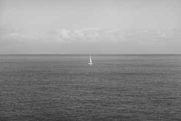 Fototapeta premium Ship sailing on the Atlantic Ocean on a sunny day seen from the island of Tenerife, Spain in black and white
