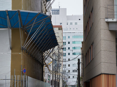 街のビルの工事現場の防音シートと落下防止の様子