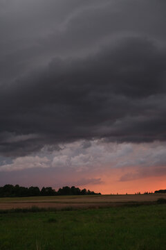 Dramatic Storm Clouds Over Field at Sunset