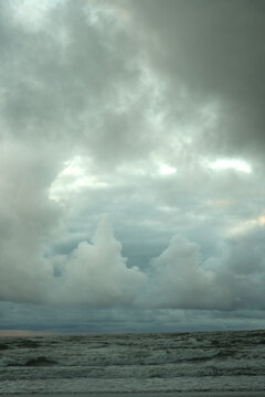 Dramatic Storm Clouds Loom Over Turbulent Ocean Waters on a Grey, Overcast Day