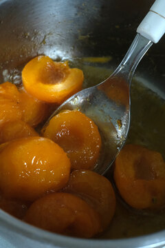 Sweet Apricot Halves Cooking in Saucepan with Spoon