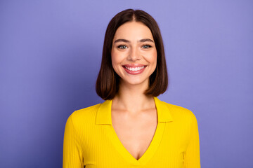 Obraz premium Happy brunette woman in bright yellow blouse smiling against purple background lifestyle fashion stock photo