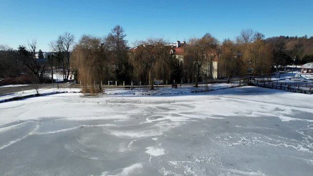 Zima w Zebrzydowicach na Śląsku w Polsce z lotu ptaka. Park z pałacem i zamarzniętym stawem.
