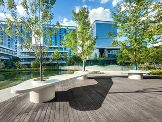 Serene Urban Oasis: A Modern Park Bench Surrounded by Lush Greenery and Contemporary Architecture
