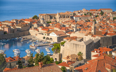 Panoramic view of Dubrovnik old town with historic walls, red tiled roofs and Adriatic Sea. Bright summer light and iconic architecture make this image perfect for travel advertising 