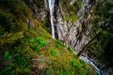 Fototapeta premium Hiking Trail to the Klammbach Waterfalls in the Antholz Valley South Tyrol in autumn 2025