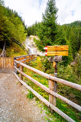 Fototapeta premium Hiking Trail to the Klammbach Waterfalls in the Antholz Valley South Tyrol in autumn 2025