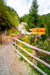 Fototapeta premium Hiking Trail to the Klammbach Waterfalls in the Antholz Valley South Tyrol in autumn 2025