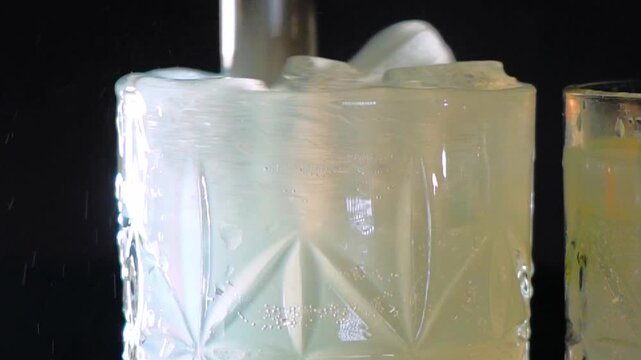 Delicious alcoholic cocktail made with jin tonic and ice in glasses for relaxing at night and refreshing in the summer. Spices and green lime for flavor. Bartender and bar. Rosemary burns with fire