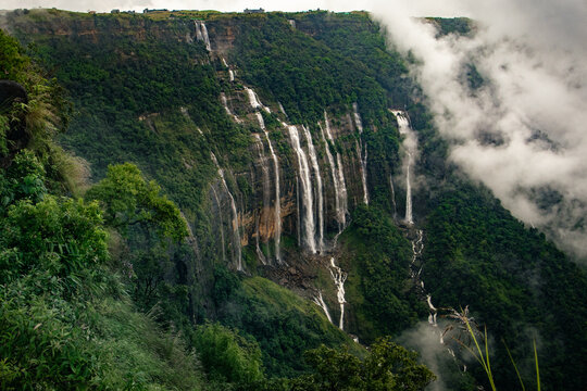 Seven sisters waterfall in sohra cherrapunji meghalaya cascading down canyon cliff covered in monsoon greens and clouds drifting. Popular tourist attraction.