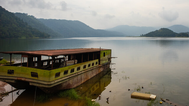 Houseboat moored on Umiam Lake surrounded by misty hills in Meghalaya India