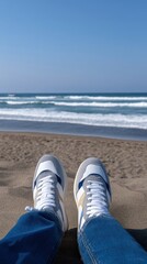 Obraz premium Close Up of Sneakers on Sandy Beach with Waves and Clear Blue Sky