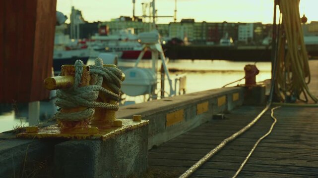 Mooring bollard with ropes on a pier with a wide view of the harbor and sea, 4K.