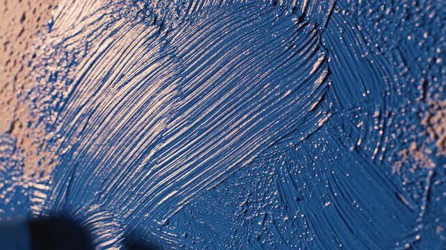 Vibrant deep blue paint applied with visible brush strokes and rich texture on a textured wall