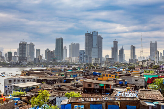 Urban slum and modern Mumbai skyline.