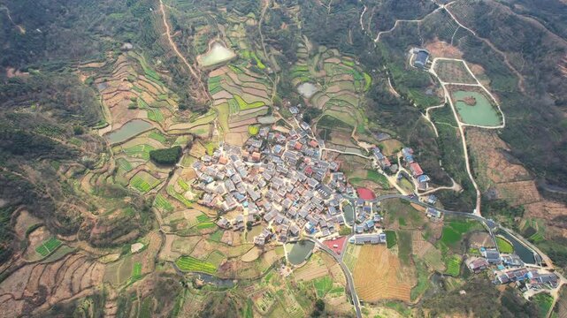 Aerial View of Rural Village Surrounded by Terraced Rice Paddies