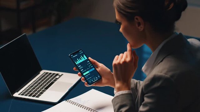 Woman checks stock on phone.