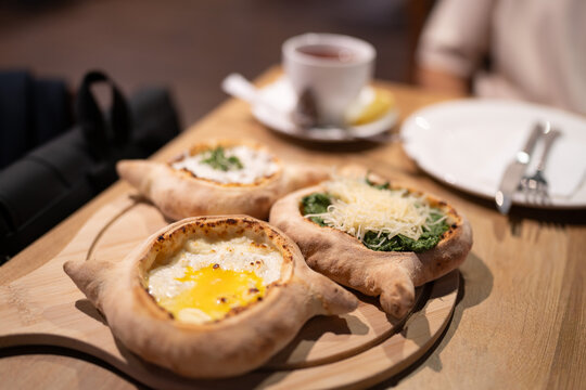Traditional Georgian breakfast table with three mini khachapuri varieties, cheese-egg filled, spinach khachapuri, and chicken khachapuri. Khachapuri, one of Georgia&rsquo;s most iconic dishes.