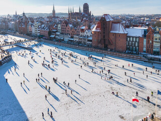 Hundreds of people walk along the frozen Motława River in Gdańsk during a frosty winter. Poland