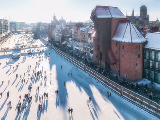 Hundreds of people walk along the frozen Motława River in Gdańsk during a frosty winter. Poland